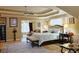Relaxing primary bedroom featuring a sitting area, tray ceiling, and doorway to living area at 7435 Woodruff Way, Stone Mountain, GA 30087