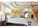 This primary bedroom features a tray ceiling, hardwood floors, and seating area at 7435 Woodruff Way, Stone Mountain, GA 30087