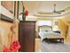 This primary bedroom features a tray ceiling, ceiling fan, and neutral walls with hardwood floors at 7435 Woodruff Way, Stone Mountain, GA 30087