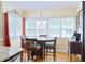 Inviting dining area with a table set for four, hardwood floors, and bright natural light from the windows at 7435 Woodruff Way, Stone Mountain, GA 30087
