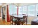 Sunlit dining area featuring a round table, four chairs, hardwood floors, and large windows at 7435 Woodruff Way, Stone Mountain, GA 30087
