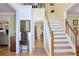 Home foyer area with staircase, hardwood floors, and small cabinet at 7435 Woodruff Way, Stone Mountain, GA 30087