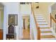Home foyer area with staircase, hardwood floors, and small cabinet at 7435 Woodruff Way, Stone Mountain, GA 30087
