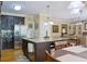 Open-concept kitchen with granite island, stainless appliances, hardwood floors, and access to the living room at 7435 Woodruff Way, Stone Mountain, GA 30087