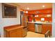 A compact kitchenette with wood cabinets, stainless steel appliances, and open shelving at 7435 Woodruff Way, Stone Mountain, GA 30087