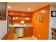 An efficient kitchenette features wood cabinets, granite countertops, and floating shelves at 7435 Woodruff Way, Stone Mountain, GA 30087