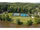 Scenic aerial view of community tennis courts with lush greenery and lake access, promising an active lifestyle at 7435 Woodruff Way, Stone Mountain, GA 30087