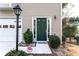 Close up of front door with dark green color flanked by a lamp post and shrubs at 805 Abbotts Mill Ct # 74, Duluth, GA 30097