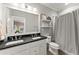Bathroom with double sink vanity, walk-in shower with grey curtain and tiled walls at 1104 Victoria Ne St, Brookhaven, GA 30319