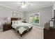 Well-lit bedroom featuring a cozy bed, dresser, and a view of the outdoors at 1104 Victoria Ne St, Brookhaven, GA 30319