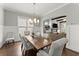 Spacious dining room with a large wooden table, designer lighting, and seamless flow to the living area at 1104 Victoria Ne St, Brookhaven, GA 30319
