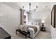 Comfortable bedroom with neutral tones, a padded headboard, modern light fixture and a bench at 5360 Hyde Rd, Cumming, GA 30040