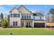 Two-story home with a well-manicured lawn, gray brick, black shutters, and a two-car garage at 5360 Hyde Rd, Cumming, GA 30040