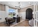 Well-lit home office with dark wood desk, stylish decor, and large windows offering natural light at 5360 Hyde Rd, Cumming, GA 30040
