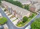Aerial view of brick townhomes featuring manicured landscaping and private driveways in a neighborhood at 6054 China Rose Ln, Duluth, GA 30097