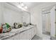 Bright bathroom featuring a marble countertop, double vanity sinks, and a walk-in shower at 6054 China Rose Ln, Duluth, GA 30097