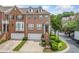Brick townhouse with two-car garage, manicured landscaping, and inviting front entrance, radiating curb appeal at 6054 China Rose Ln, Duluth, GA 30097