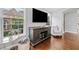 Comfortable living area with large windows, a wooden TV stand, and hardwood floors at 6054 China Rose Ln, Duluth, GA 30097
