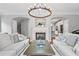 Spacious living room with fireplace, couches, coffee table, and view into the kitchen at 6054 China Rose Ln, Duluth, GA 30097
