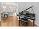 Living area featuring a black piano and view into the kitchen with pendant lighting at 6054 China Rose Ln, Duluth, GA 30097