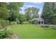 Well-maintained backyard featuring manicured lawn, mature trees, a garage, and decorative landscaping at 655 E Pelham Ne Rd, Atlanta, GA 30324