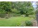 Landscaped backyard with manicured lawn, lush garden beds, hedges, and fenced perimeter at 655 E Pelham Ne Rd, Atlanta, GA 30324