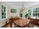 Elegant dining room with chandelier, wood table, and large windows at 655 E Pelham Ne Rd, Atlanta, GA 30324