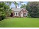 Charming brick home with a lush green lawn and beautiful landscaping at 655 E Pelham Ne Rd, Atlanta, GA 30324
