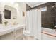 Modern bathroom with tub and shower, dark horizontal tiles, updated vanity, and white shower curtain at 1231 Mansfield Ne Ave, Atlanta, GA 30307