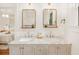Bathroom features double sink vanity with marble countertop, grey cabinetry, and matching mirrors with modern light fixtures at 1231 Mansfield Ne Ave, Atlanta, GA 30307