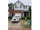 Two-story townhome with a brick facade, black shutters, and an attached garage and well-maintained landscaping at 116 Madeline Ct, Mcdonough, GA 30253