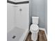 This bathroom features a white shower and toilet with wood-look flooring at 122 Rue Fontaine, Lithonia, GA 30038
