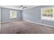 This bedroom features neutral walls, soft carpeting, and two windows for natural light at 122 Rue Fontaine, Lithonia, GA 30038