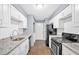 Updated kitchen featuring white cabinets, granite countertops, and stainless steel appliances at 122 Rue Fontaine, Lithonia, GA 30038
