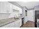 Well-lit kitchen featuring white cabinets, granite countertops, and stainless steel appliances at 122 Rue Fontaine, Lithonia, GA 30038
