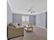 Cozy living room with neutral walls, carpet, ceiling fan, and a door leading to the outside at 122 Rue Fontaine, Lithonia, GA 30038