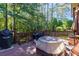 The spacious outdoor deck features grilling space with beautiful views of the wooded backyard at 2015 Towne Lake W Hls, Woodstock, GA 30189
