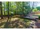 Serene backyard featuring a trampoline and a wooden retaining wall surrounded by tall trees at 2015 Towne Lake W Hls, Woodstock, GA 30189