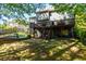Backyard featuring a large deck with stairs and mature trees at 2015 Towne Lake W Hls, Woodstock, GA 30189