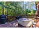 Backyard deck featuring outdoor cooking equipment, perfect for grilling and entertaining, surrounded by lush trees and nature at 2015 Towne Lake W Hls, Woodstock, GA 30189