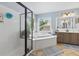 Bright bathroom featuring a tub, separate shower, and a double sink vanity at 2015 Towne Lake W Hls, Woodstock, GA 30189
