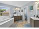Bright bathroom with soaking tub, double vanity, and neutral tile flooring at 2015 Towne Lake W Hls, Woodstock, GA 30189