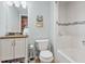 Bright bathroom with vanity, toilet, and tiled shower/tub featuring decorative beach decor at 2015 Towne Lake W Hls, Woodstock, GA 30189