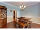 Dining room with rustic wooden table and bench seating, lit by decorative chandelier at 2015 Towne Lake W Hls, Woodstock, GA 30189