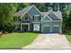 Two-story home boasting a combination of stone and siding facade, an arched window, and a well-kept front lawn at 2015 Towne Lake W Hls, Woodstock, GA 30189