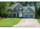 Well-maintained two-story home boasting a spacious driveway, a two-car garage, and beautiful curb appeal at 2015 Towne Lake W Hls, Woodstock, GA 30189