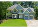 Beautiful two-story house with stone details, a 2-car garage, and a well-manicured front yard at 2015 Towne Lake W Hls, Woodstock, GA 30189