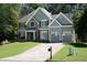 Beautiful two-story home with a two-car garage and well maintained lawn at 2015 Towne Lake W Hls, Woodstock, GA 30189