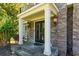 Stone front entrance with double doors, white columns, and decorative outdoor lighting at 2015 Towne Lake W Hls, Woodstock, GA 30189