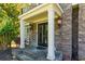 Charming front porch with stone accents, columns, and lantern-style lighting at 2015 Towne Lake W Hls, Woodstock, GA 30189